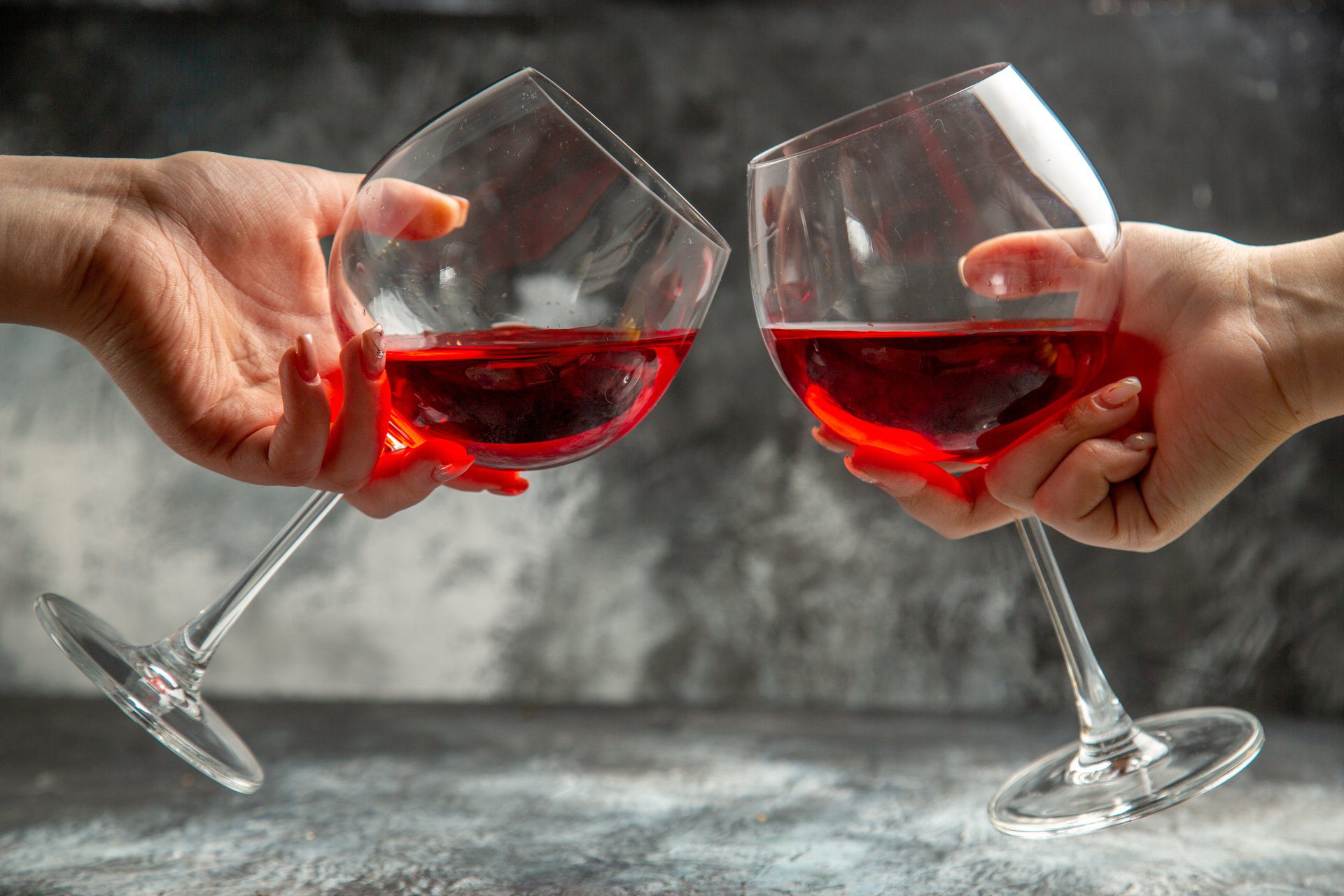 vertical view hands holding glasses dry red wine gray background x